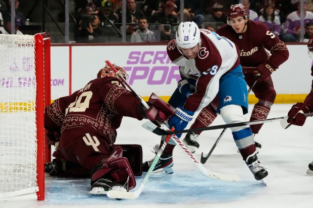 Colorado Avalanche left wing Miles Wood scores a goal against Arizona Coyotes goaltender Connor Ingram, left, as Coyotes defenseman Michael Kesselring looks on during the second period of an NHL hockey game, Thursday, Nov. 30, 2023, in Tempe, Ariz. (AP Photo/Ross D. Franklin)