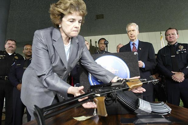 US Senator Dianne Feinstein(D-CA) grabs an AK-47 during a press conference at the Los Angeles Police Department headquarters in downtown Los Angeles on August 21, 2003. (Hector Mata/AFP via Getty Images)
