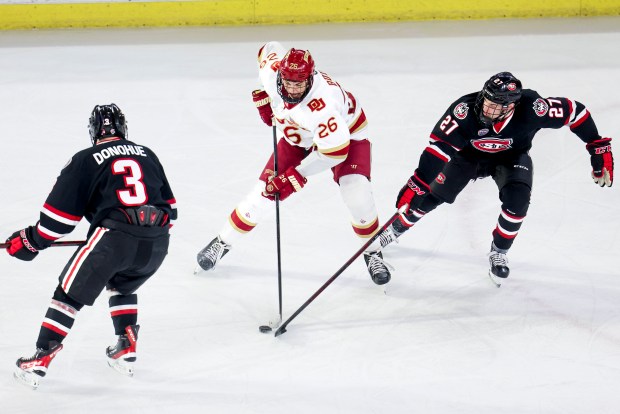 DENVER, CO - FEBRUARY 04: Denver defenseman Shai Buium (26) attempts to make a pass around St. Cloud State forward Chase Brand (27) in the second period at Magness Arena Friday, Feb. 4, 2022 in Denver, Colorado. (Photo by Michael Ciaglo/Special to The Denver Post)